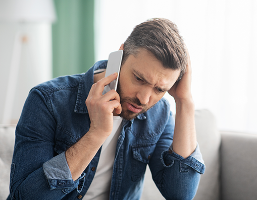 Man looking stressed whilst on his mobile phone